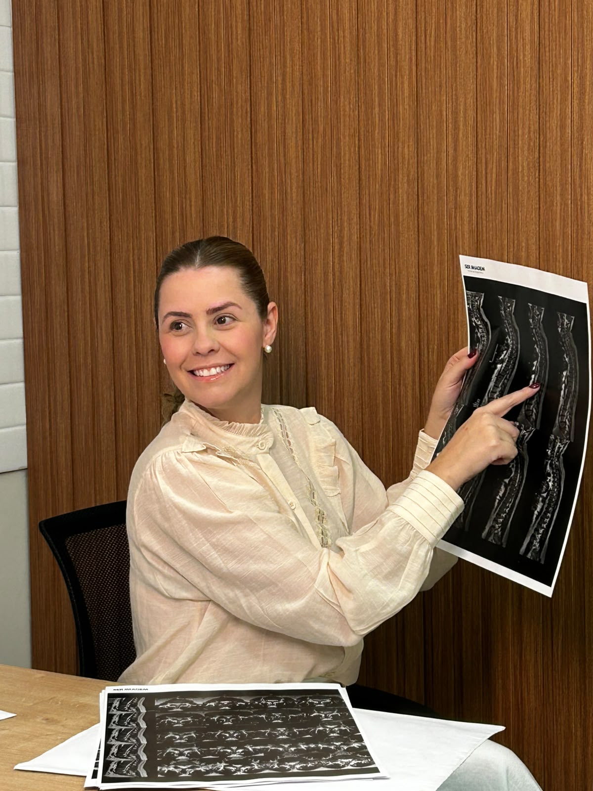 Dra. Fernanda apontando o achado em um exame de ressonância magnética